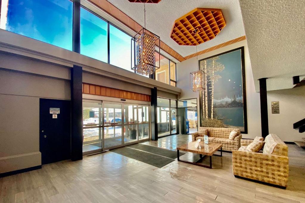 a lobby with couches and a table in a building at Ramada by Wyndham Whitecourt in Whitecourt