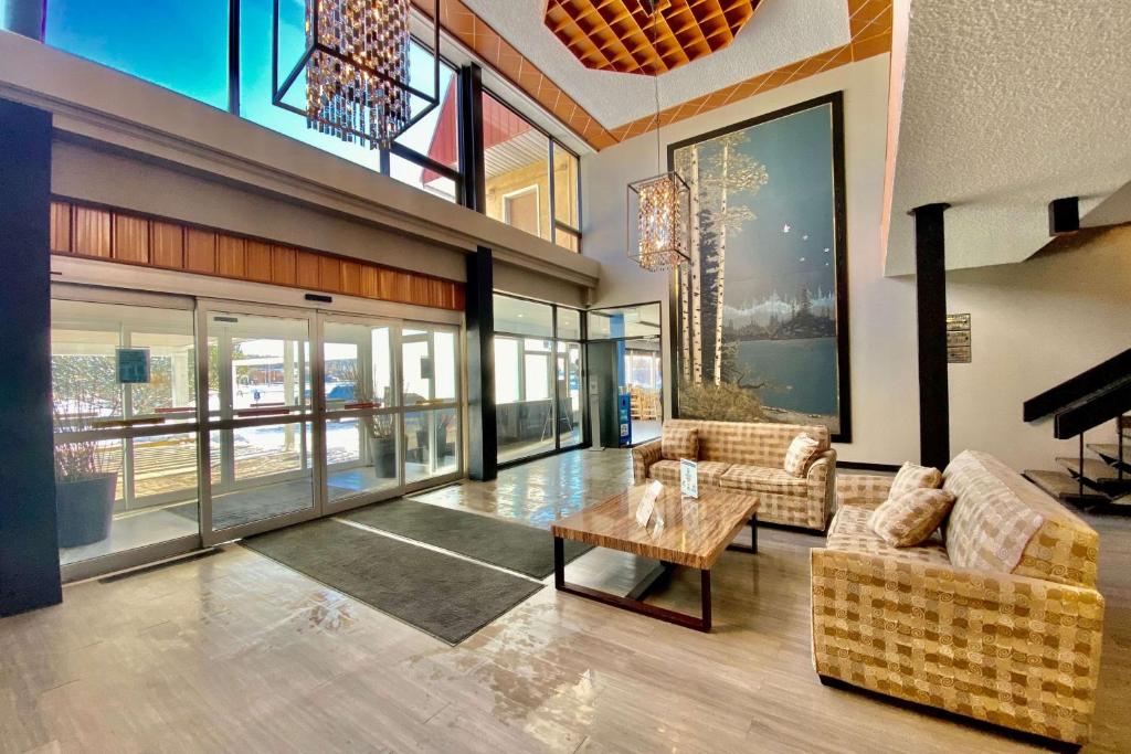 a living room with two couches and a table at Ramada by Wyndham Whitecourt in Whitecourt