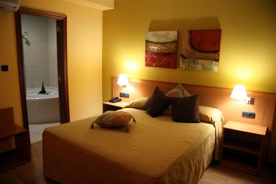 - une chambre avec un lit et une salle de bains pourvue d'une baignoire dans l'établissement Hotel Leyton, à Foz