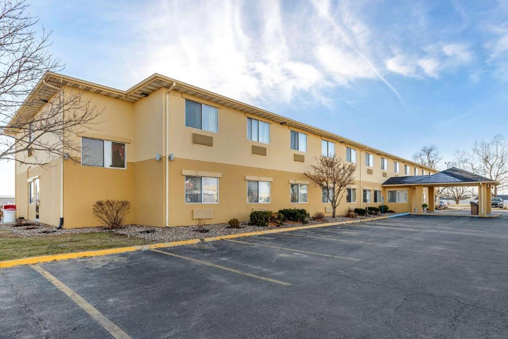 un grand bâtiment jaune avec un parking dans l'établissement Quality Inn Kirksville, à Kirksville