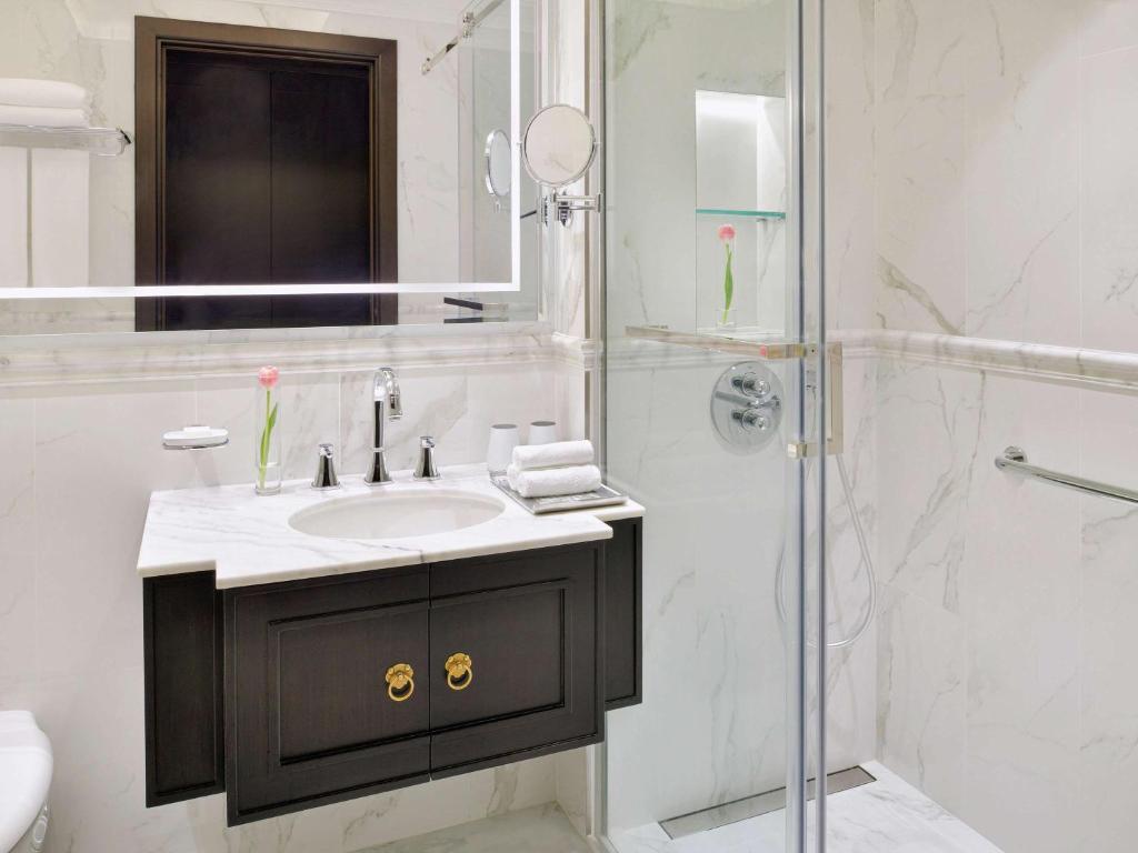 a bathroom with a sink and a shower at Mövenpick Hotel Bahrain in Manama