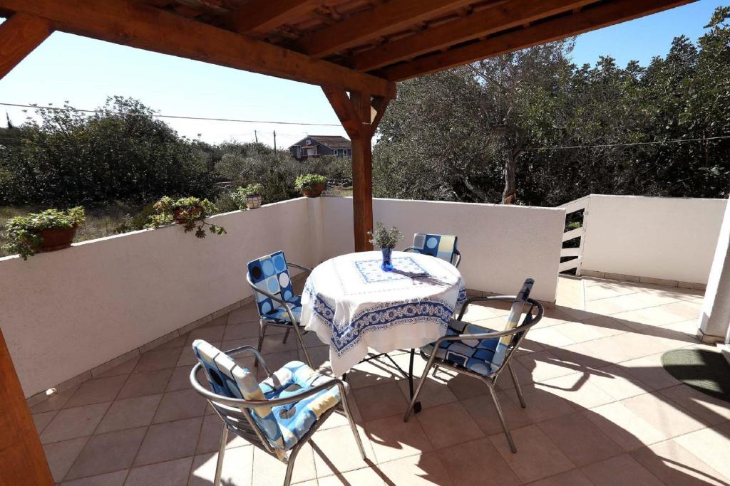 einen Tisch und Stühle auf einer Terrasse mit einem Zaun in der Unterkunft Apartment Meri in Trogir