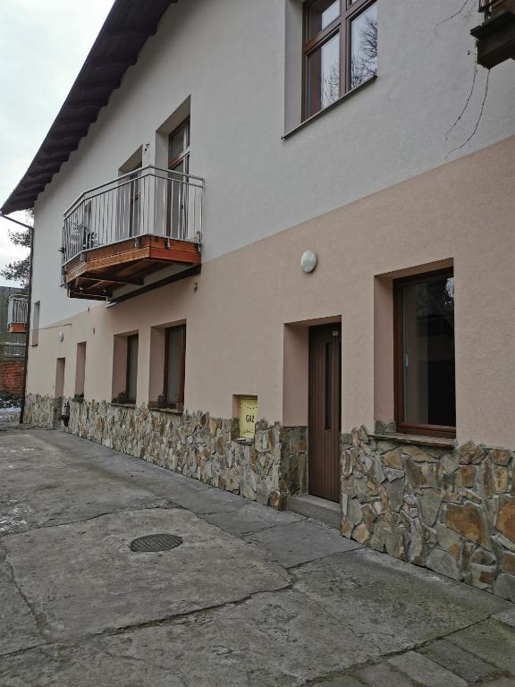 a building with two balconies and a stone wall at Apartament Rodzinny in Nowy Targ