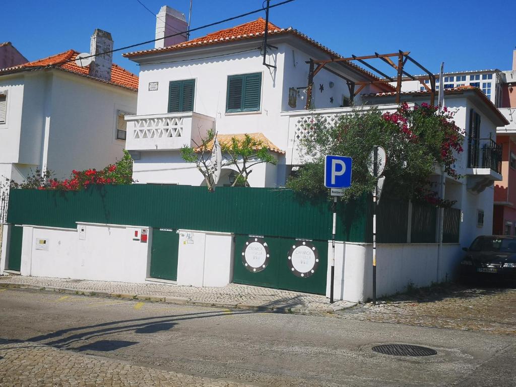 una valla frente a una casa con parquímetro en Caparica Surf Villa, en Costa da Caparica