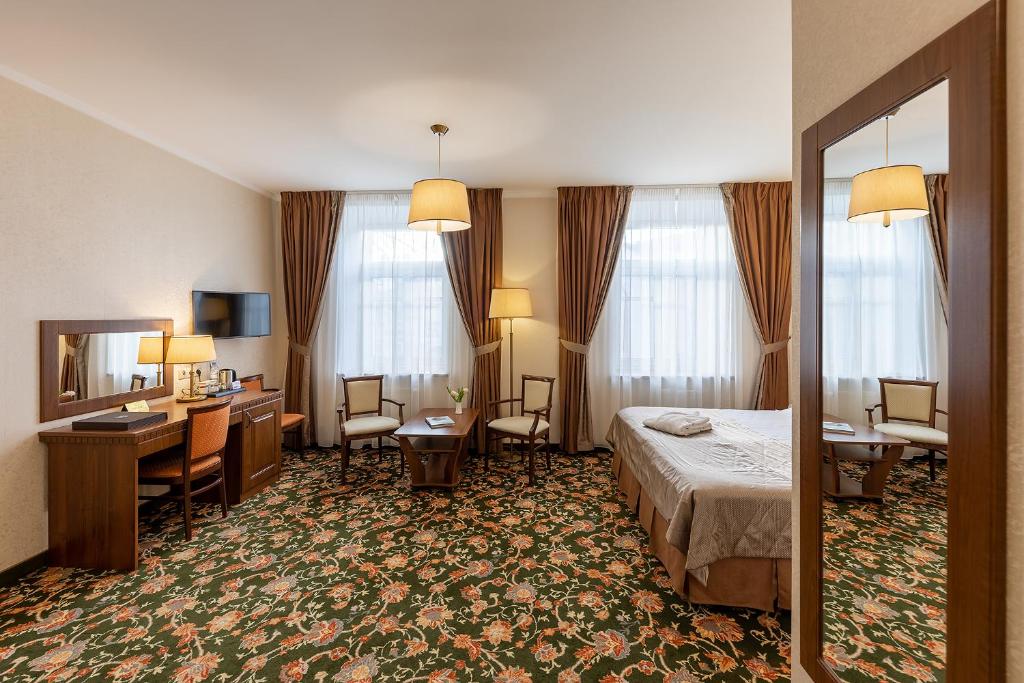 a hotel room with two beds and a table at Dvor Podznoeva - Business building in Pskov