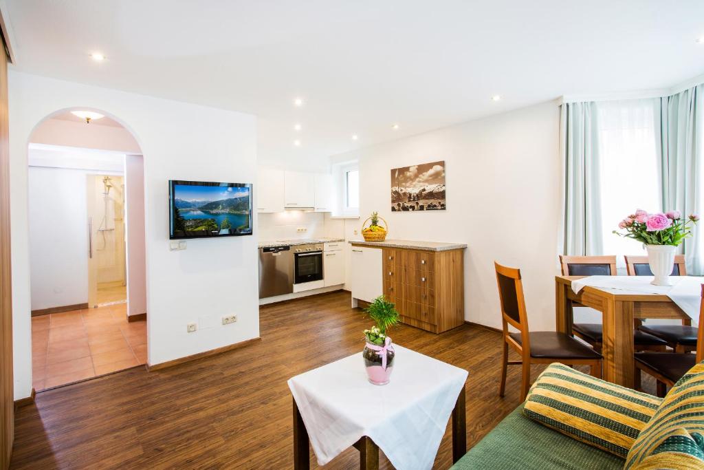 een woonkamer met een tafel en een keuken bij Neue Post - Apartments in Zell am See