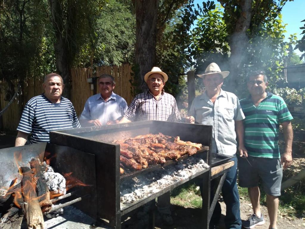 un gruppo di uomini intorno a un barbecue di El Indio - Casa de campo a Villa del Salvador