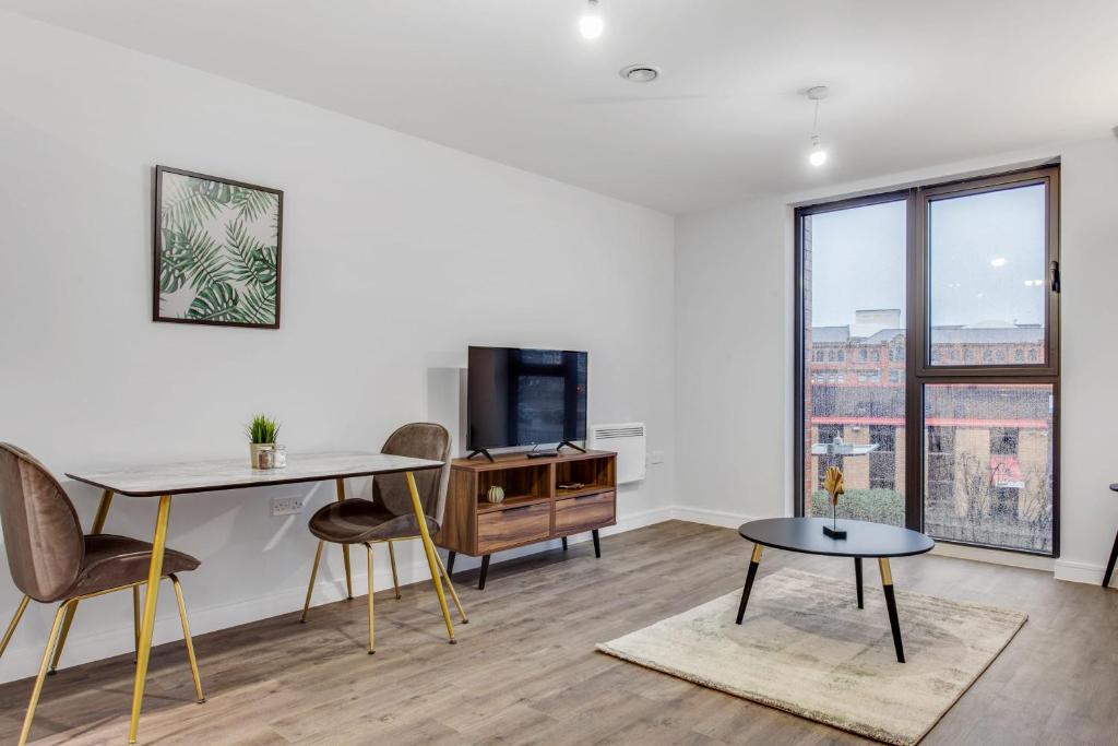 een woonkamer met een tafel en stoelen en een televisie bij Stylish and Beautiful 1 Bedroom Flat in Birmingham in Birmingham