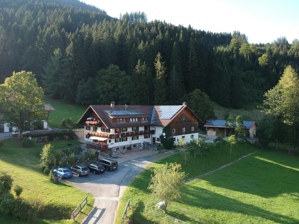 une vue aérienne sur une maison avec des voitures garées dans une allée. dans l'établissement Ferienhof Ammann, à Bad Hindelang