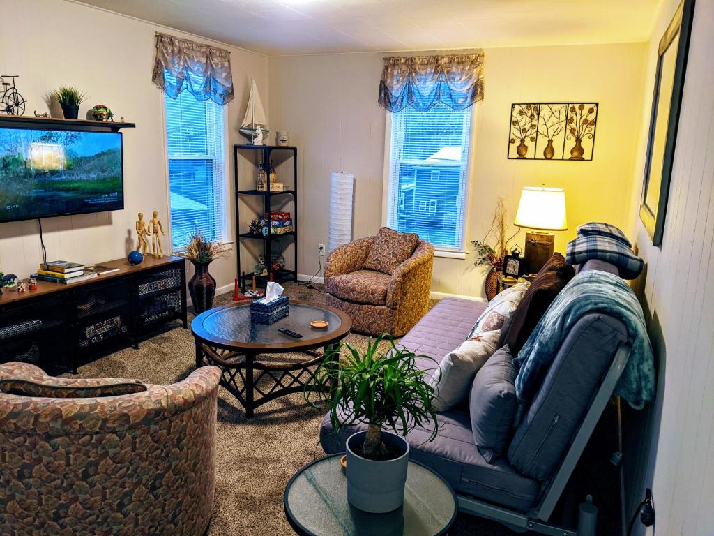 a living room with a couch and a tv at The Estate Loft in Downtown Milford in Milford