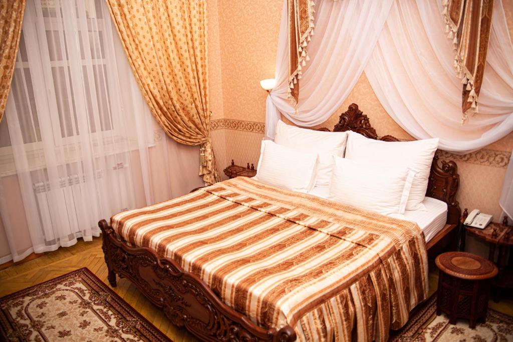 a bedroom with a bed with a canopy at INTOURIST Hotel in Volgograd