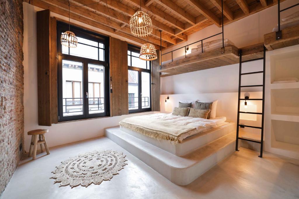 a bedroom with a large bed and some windows at Boutique Holiday Home Zalig In Antwerpen in Antwerp