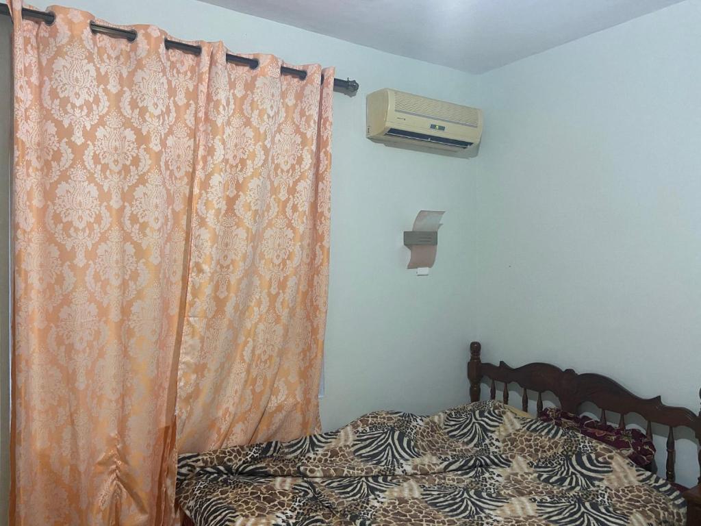 um quarto com uma cama com uma cortina laranja em Kooshal Seetul House Villa - Room em Centre de Flacq