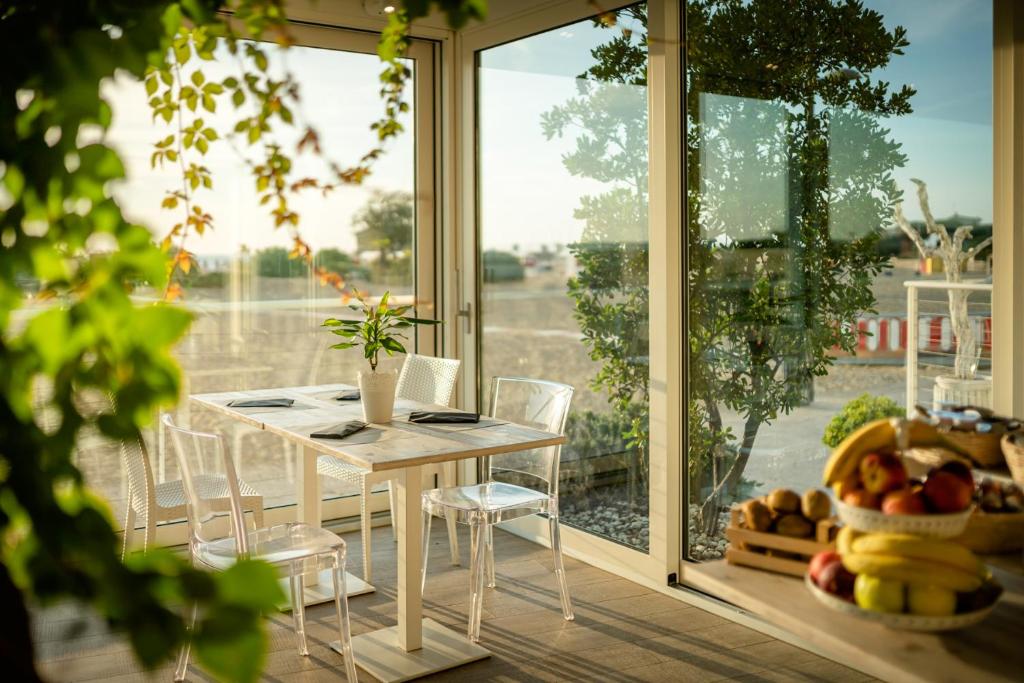a table and chairs in a room with a window at Stellamare in Caorle