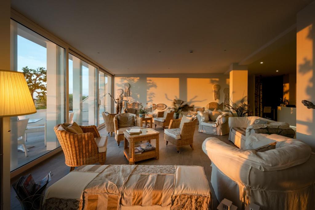 a living room with couches and chairs and a large window at Stellamare in Caorle