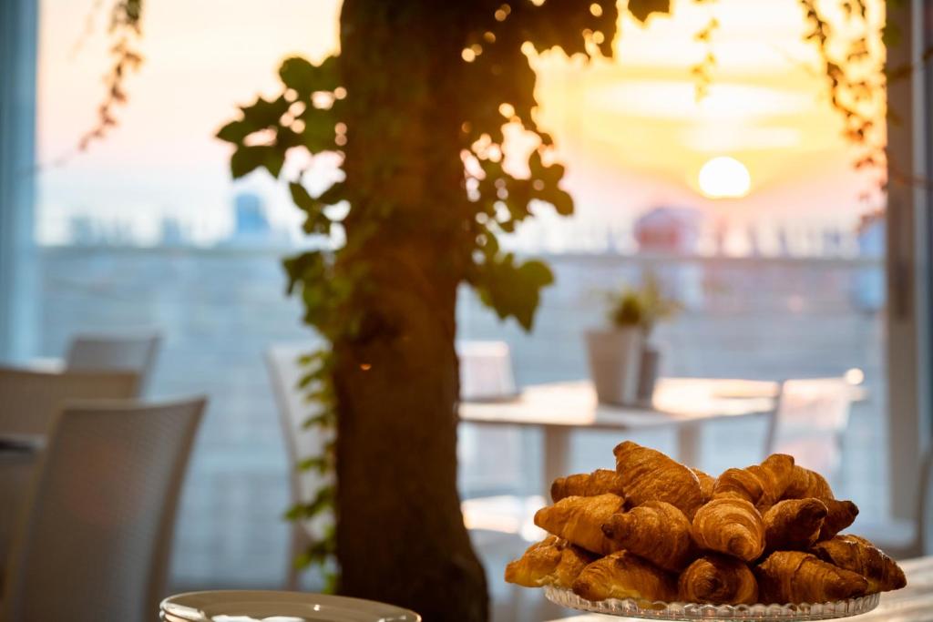 a plate of pastries on a table next to a tree at Stellamare in Caorle