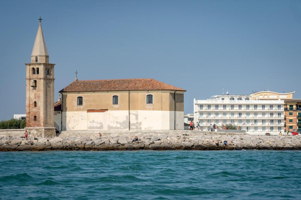 a building on the water with a church and a tower at Stellamare in Caorle