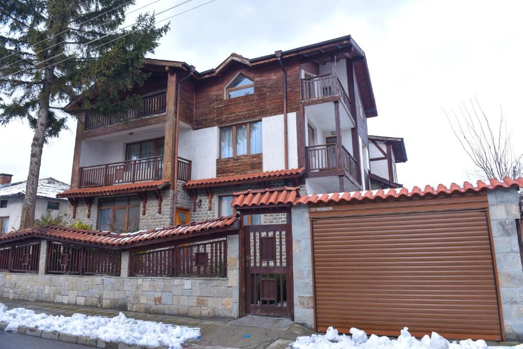 una casa grande con un garaje delante en Guest rooms Bansko en Bansko