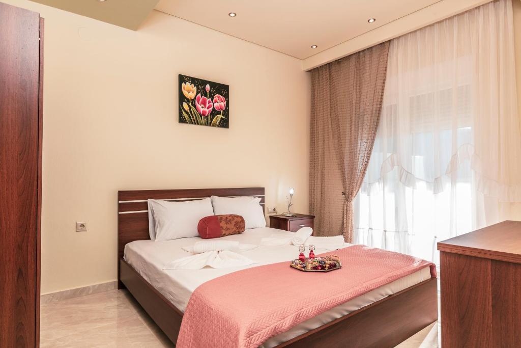 una camera con un letto e una coperta rosa di Loridis View Apartments a Prinos