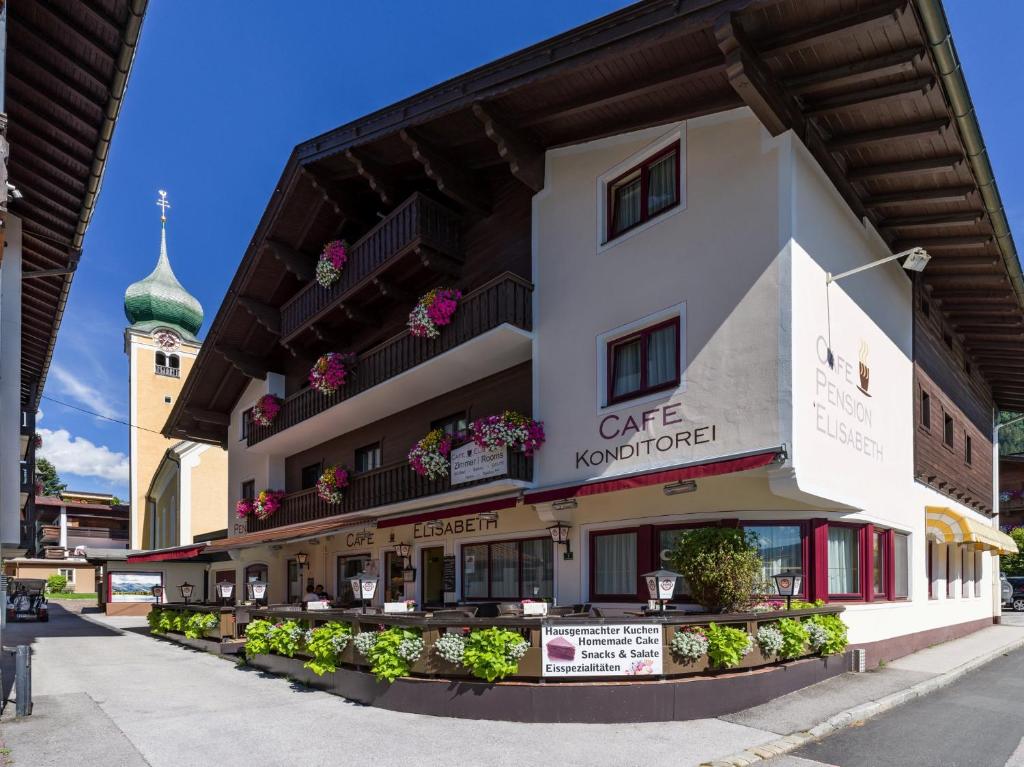 ein großes Gebäude mit Blumen an der Seite in der Unterkunft Pension Elisabeth in Westendorf