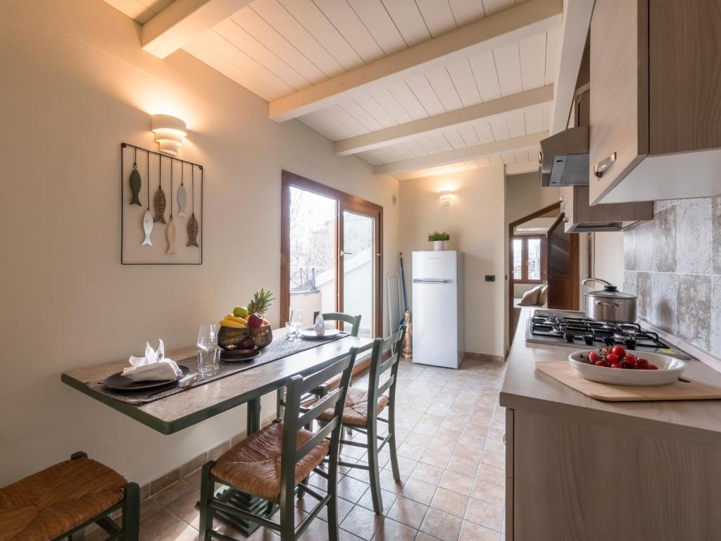 kuchnia z blatem z krzesłami i kuchenką w obiekcie Appartamenti Villa Tonni w mieście Gabicce Mare