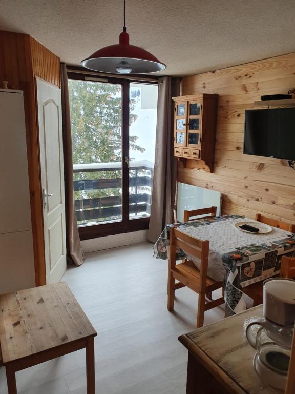 une cuisine avec une table et une grande fenêtre dans l'établissement Appartement Combes Blanche 2, à Manigod