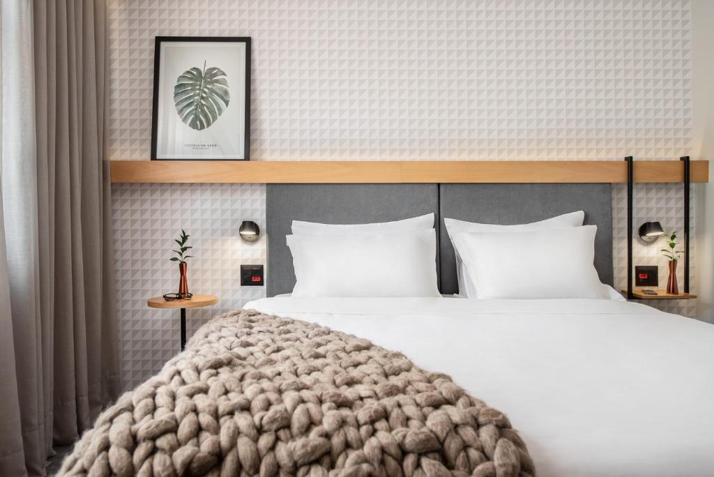 a bedroom with a large bed with white pillows at Intercity Porto Alegre Aeroporto in Porto Alegre