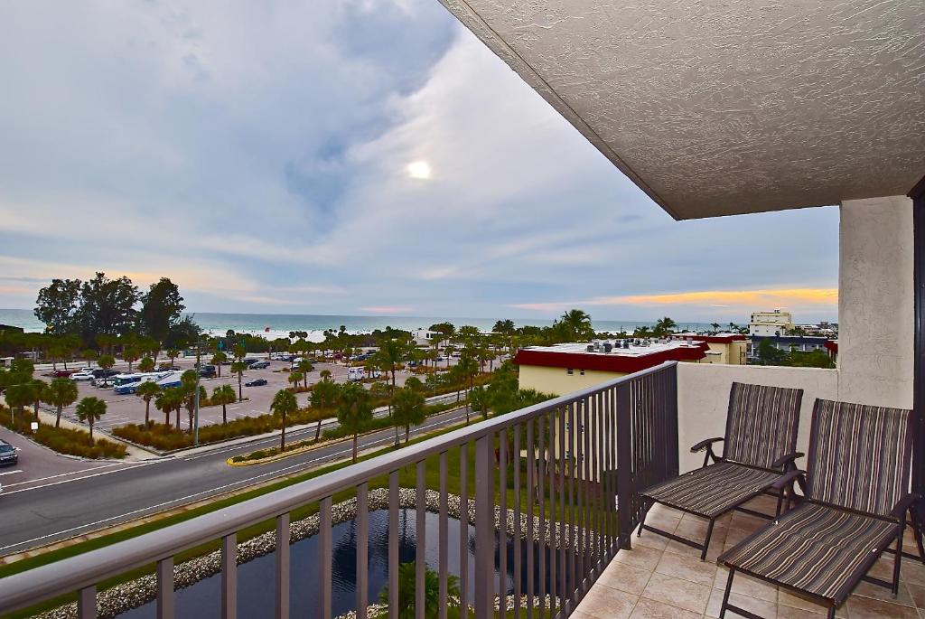 a balcony with two chairs and a view of a street at Our House at the Beach 501W in Siesta Key