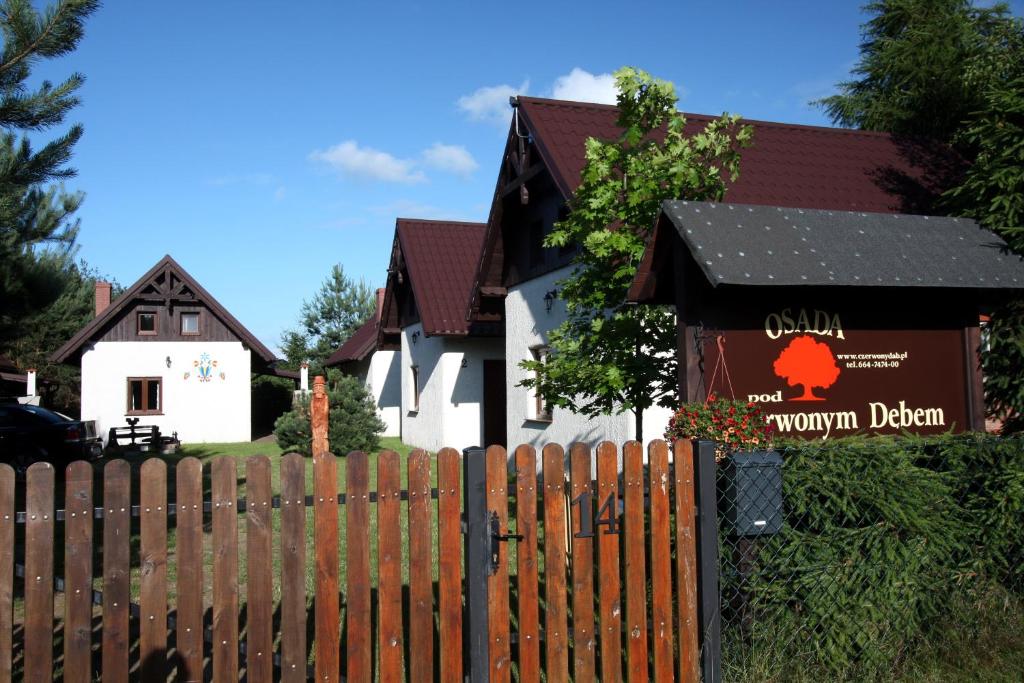 uma cerca em frente a uma casa com um sinal em Osada pod Czerwonym Dębem - Czarny Młyn em Jastrzebia Gora