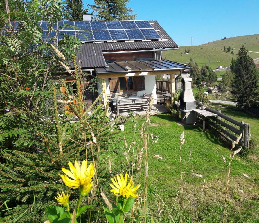 una casa con paneles solares en el techo en Sommeralmhütte en Sankt Kathrein am Offenegg