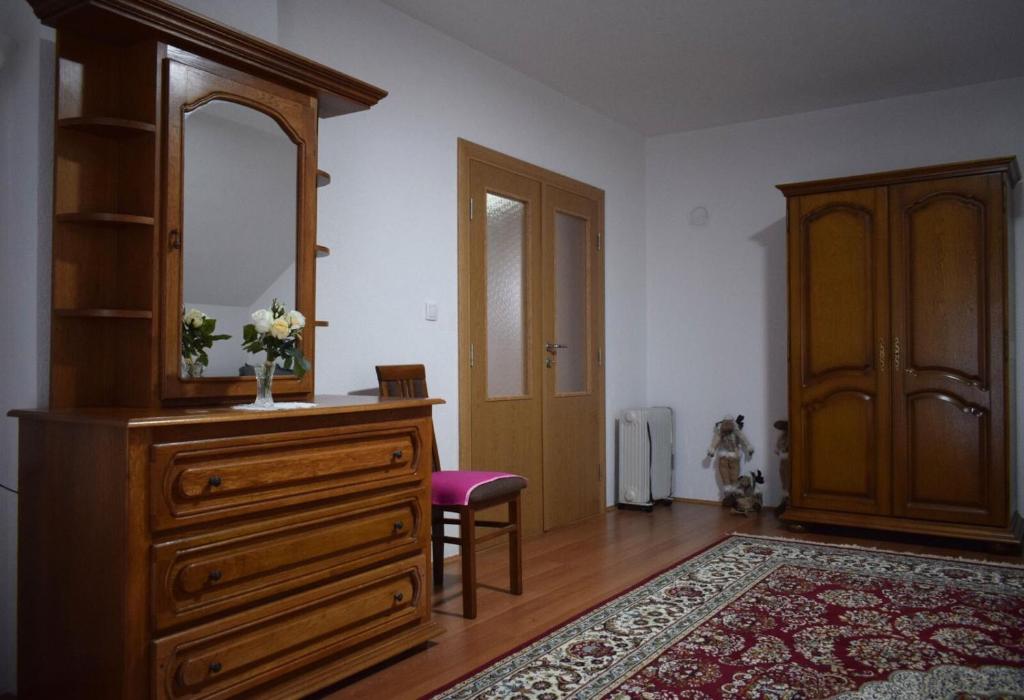 een kamer met een houten dressoir en een spiegel bij Vila Jakovljević in Jošanička Banja