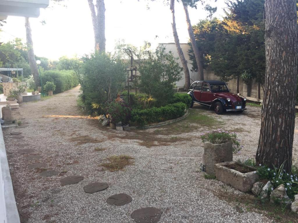 ein rotes Auto, das in einer Einfahrt neben einem Haus parkt in der Unterkunft Villa nel Salento - Casa Maria e Casa Glory in Porto Cesareo