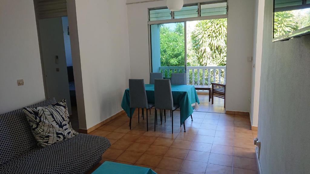 ein Esszimmer mit einem blauen Tisch und Stühlen in der Unterkunft Bas de villa 80m2 entrée et jardin privés à 500 metres de la plage in Sainte-Anne