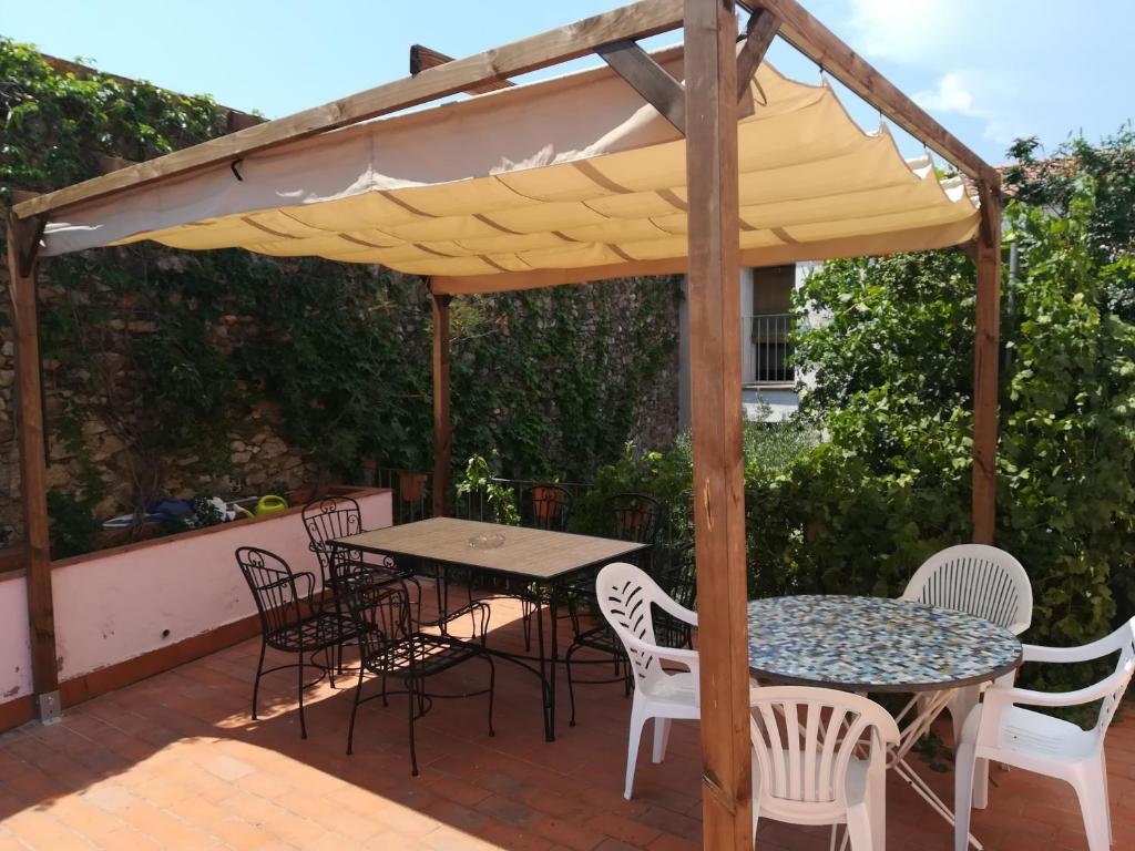 uma mesa e cadeiras sob um guarda-sol num pátio em Casa Rural El Pati de l´Albera em Sant Climent Sescebes