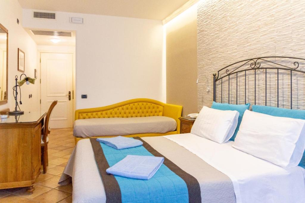 a hotel room with two beds in a room at Hotel Trinacria in San Vito lo Capo