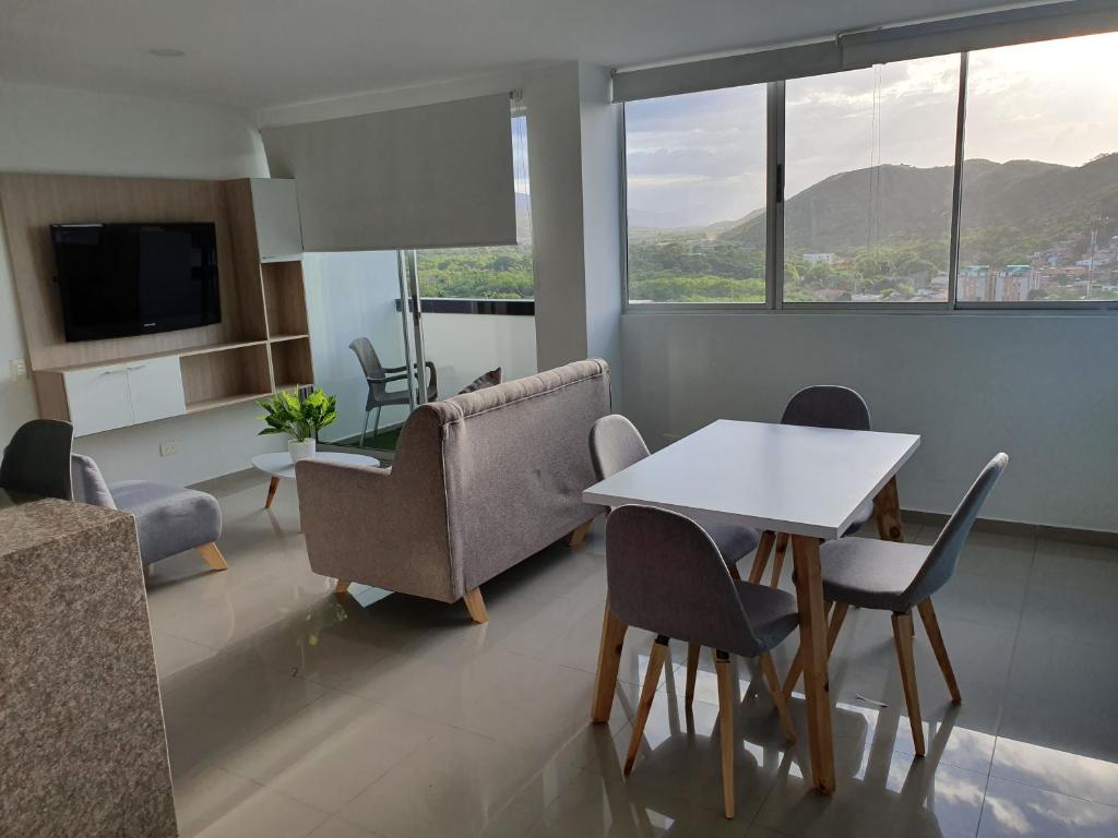 een woonkamer met een tafel en stoelen bij Excelente Apartamento Completo, en la mejor zona in Cúcuta