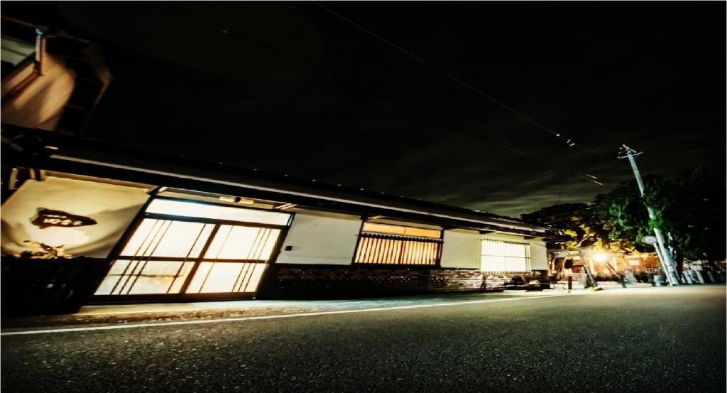 ein Gebäude in der Nacht mit beleuchteten Fenstern auf einer Straße in der Unterkunft Rural house for rent - Vacation STAY 18282v in Susami