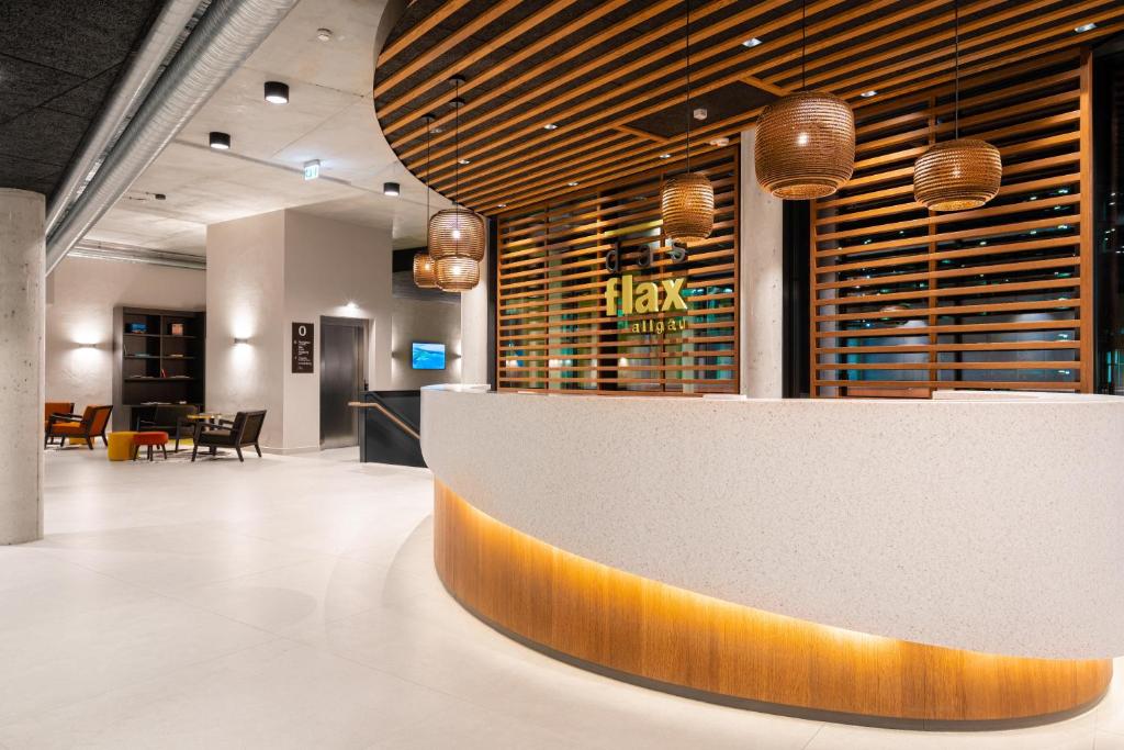 a restaurant lobby with a large reception counter with aitating at das flax allgäu in Dietmannsried