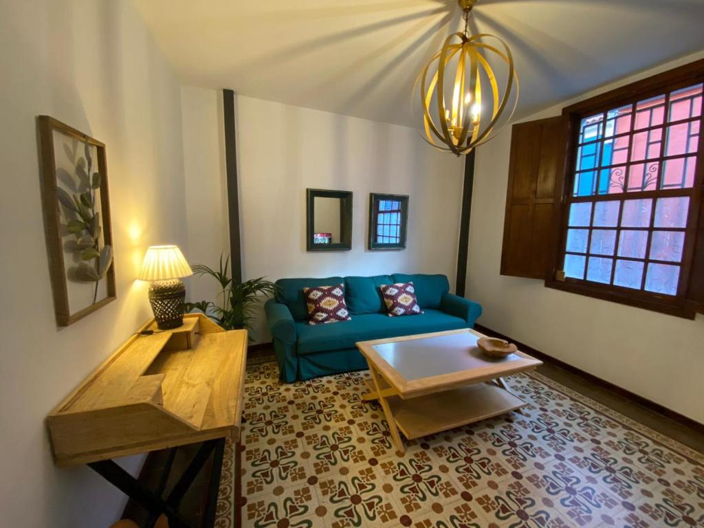 a living room with a blue couch and a table at Old Town House La Laguna in Las Lagunas