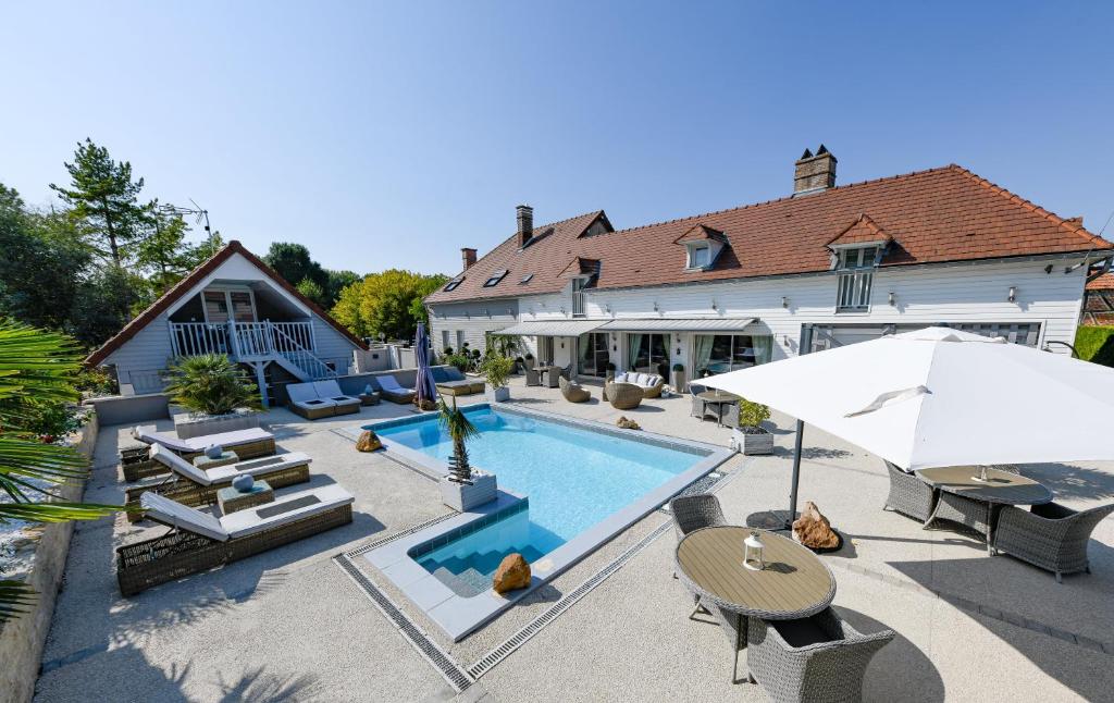 een huis met een zwembad en een patio bij Villa de la Croix in Villechétif