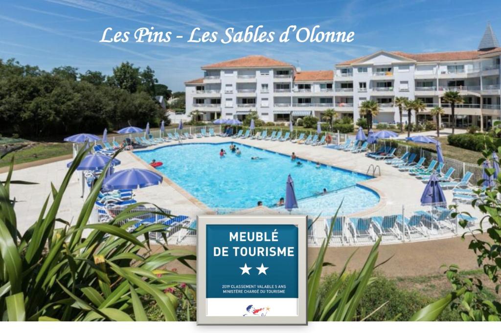 a large swimming pool with a sign in front of a resort at Les Pins - 3 pièces - Vue sur piscine - 600m mer - Les Sables d'Olonne in Les Sables-dʼOlonne