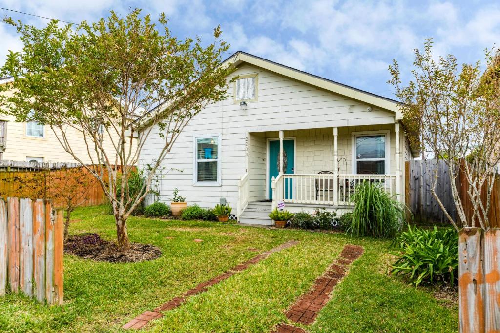 a white house with a fence in the yard at Vacation Victory in Galveston