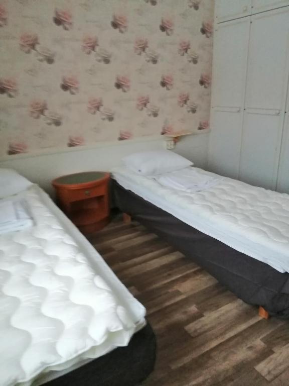 two twin beds in a room with a wooden floor at Köpsintie 4 B in Pyhäsalmi