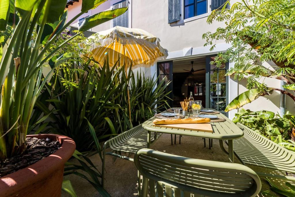 einen Tisch und Stühle auf einer Terrasse mit Pflanzen in der Unterkunft JUNGLE KEYWEEK Townhouse with terrace and garden in Biarritz