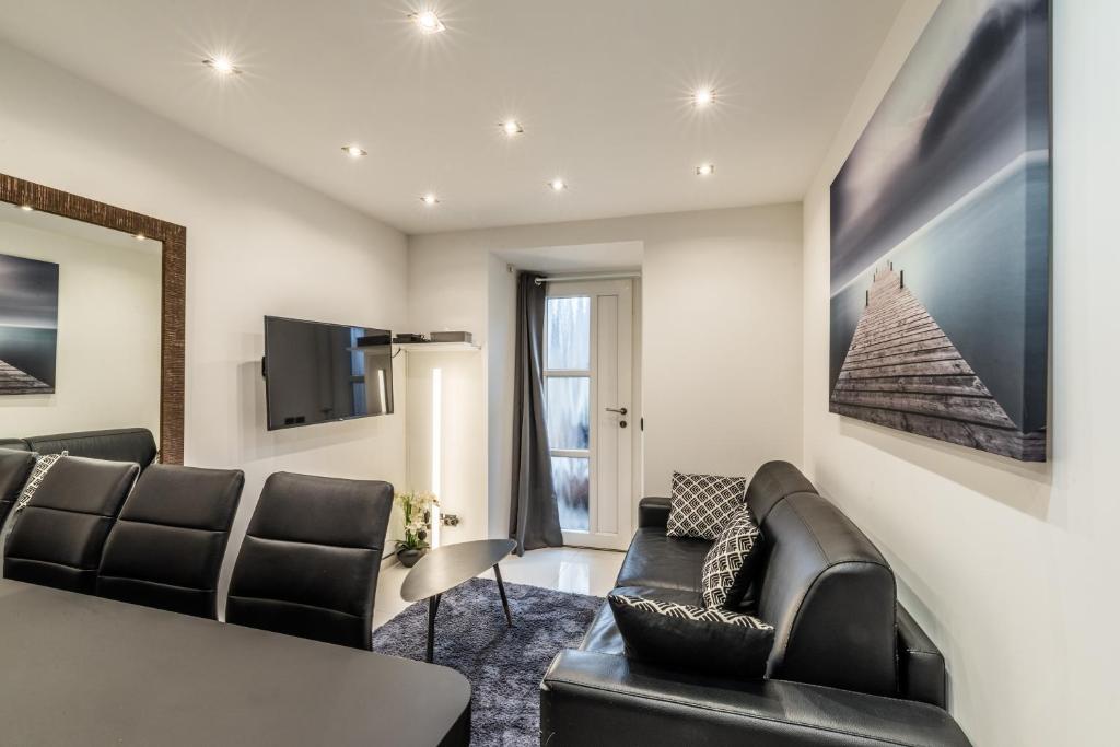 a living room with a couch and a table and chairs at Lac et Montagne in Veyrier-du-Lac