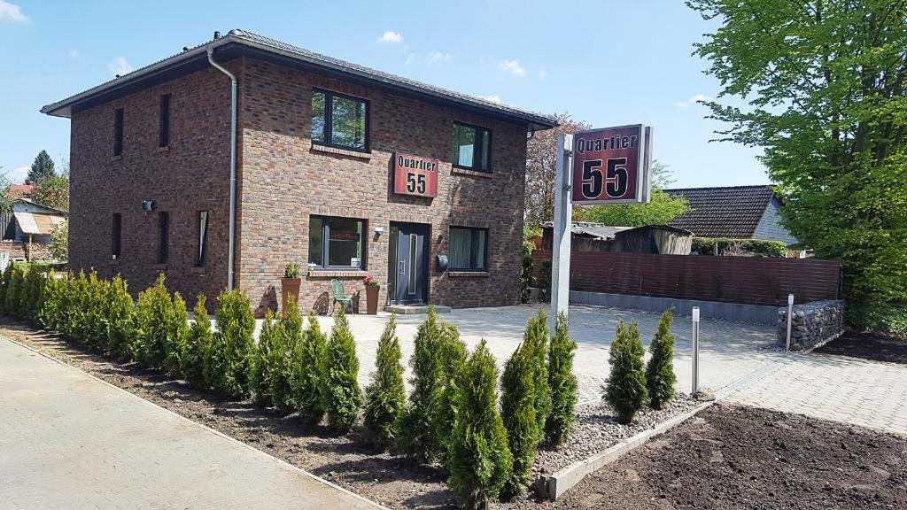 a brick building with a sign in front of it at Q55 - Quartier 55 in Quickborn