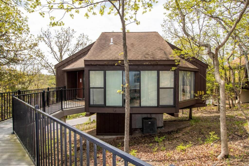 ein kleines Haus mit einem schwarzen Zaun und Bäumen in der Unterkunft Unit 110 - Treeloft 3 Bedroom Villa in Four Seasons