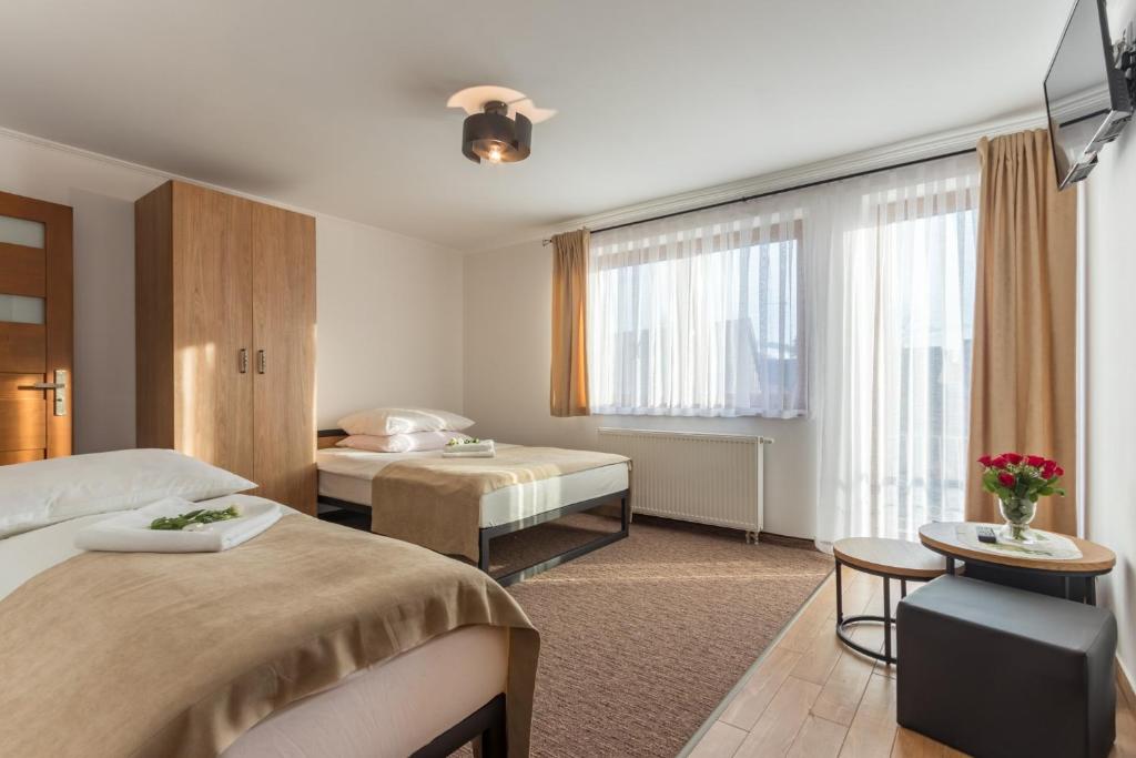 ビャウカにあるBeata Marek Pod Grapąのベッド2台とテーブルが備わるホテルルームです。