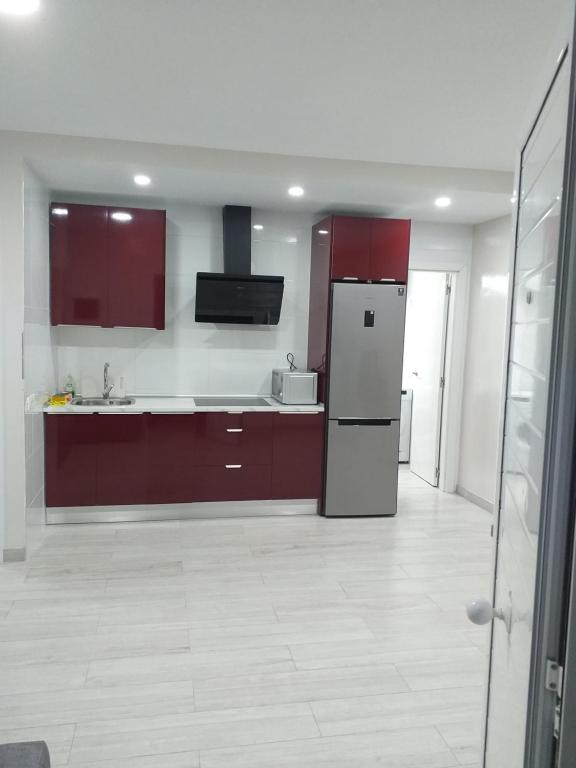 una cucina con armadi rossi e frigorifero di CASA PARAISO a Corralejo