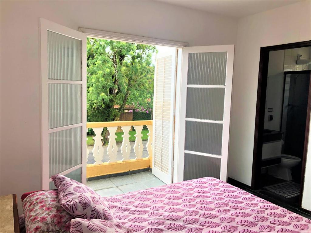 a bedroom with a bed and a large window at Flat duplex localização espetacular 2 quadras da praia in Ubatuba